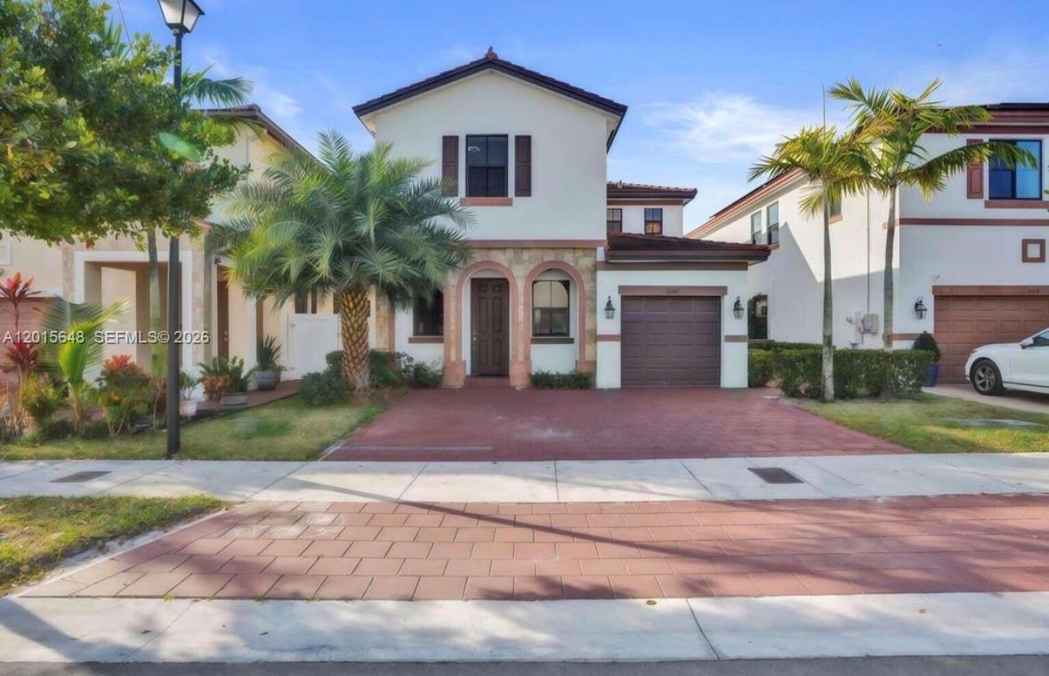 A two-story suburban house with a red brick driveway, a garage, and palm trees — 3460 W 103rd Ter, Hialeah FL 33018, HIALEAH, FL