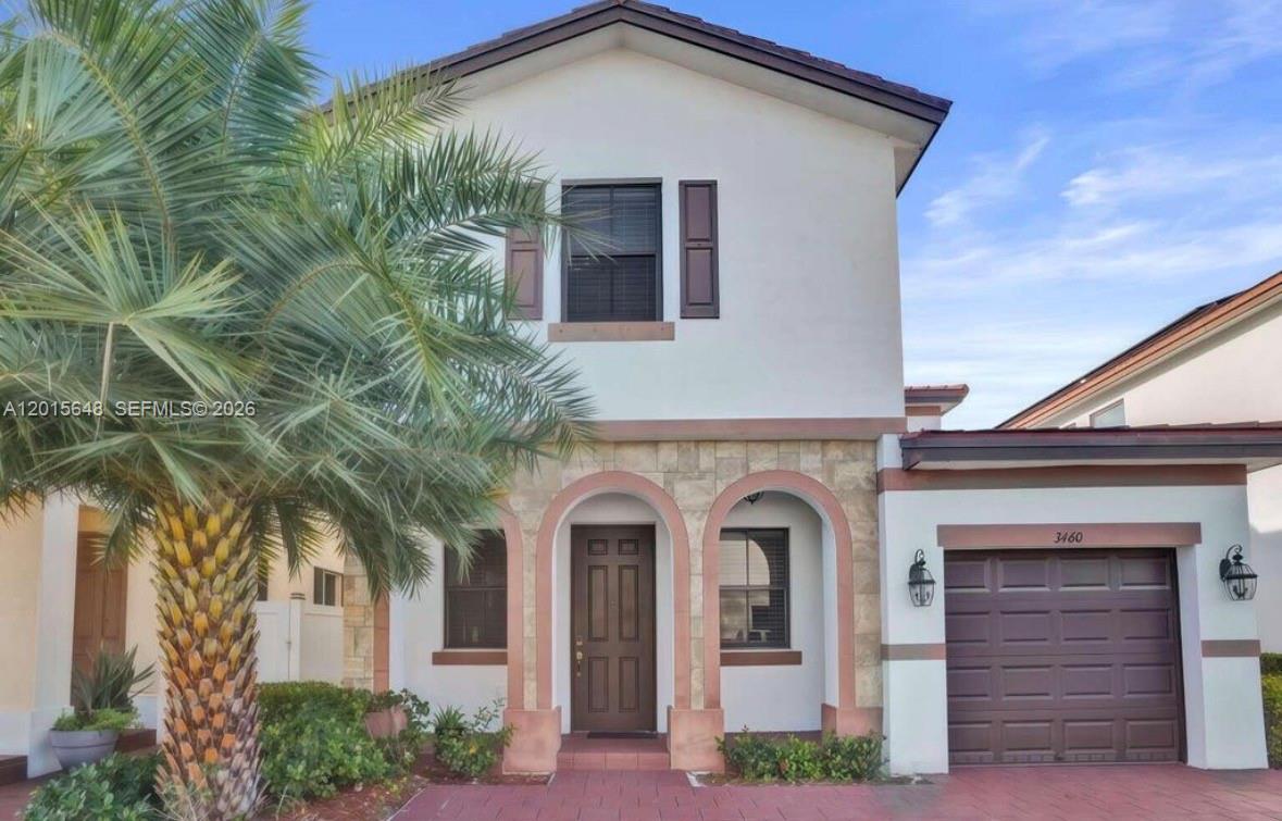 A two-story house features a stone-accented entryway, a brown garage door, and a palm tree — 3460 W 103rd Ter, Hialeah FL 33018, HIALEAH, FL