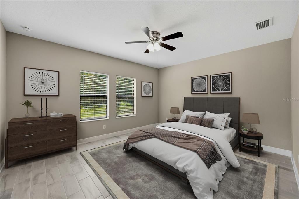A bedroom features a gray upholstered bed, a dark wood dresser, and a ceiling fan — 14519 WOODLAND SPUR DRIVE, LITHIA, FL