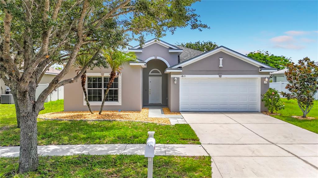 A single-story house with a gray exterior, a two-car garage, and a front yard — 1810 BONITA BLUFF COURT, RUSKIN, FL