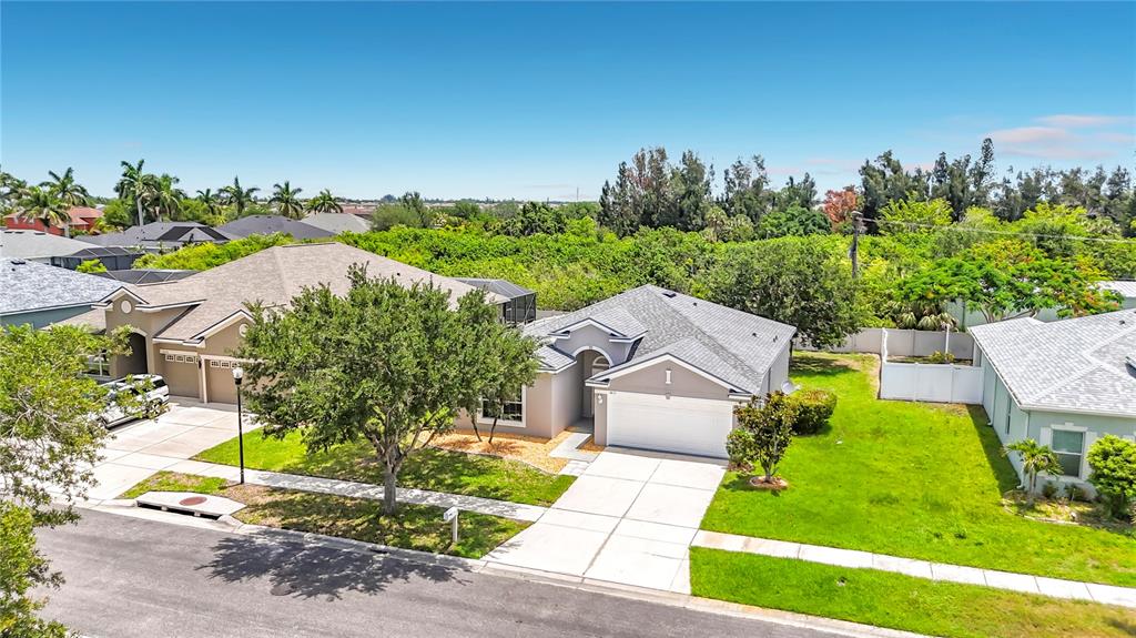 An elevated view shows two single-story suburban houses with driveways and green lawns — 1810 BONITA BLUFF COURT, RUSKIN, FL