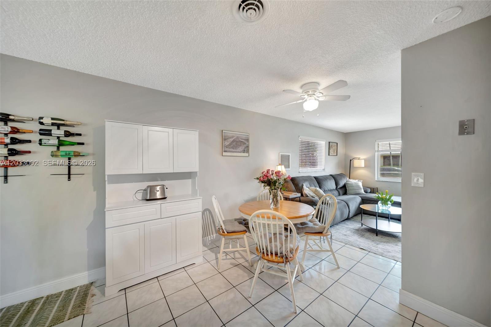 A dining area with a white hutch and wine rack opens into a living room — 2708 NW 51st Pl, Tamarac FL 33309, TAMARAC, FL