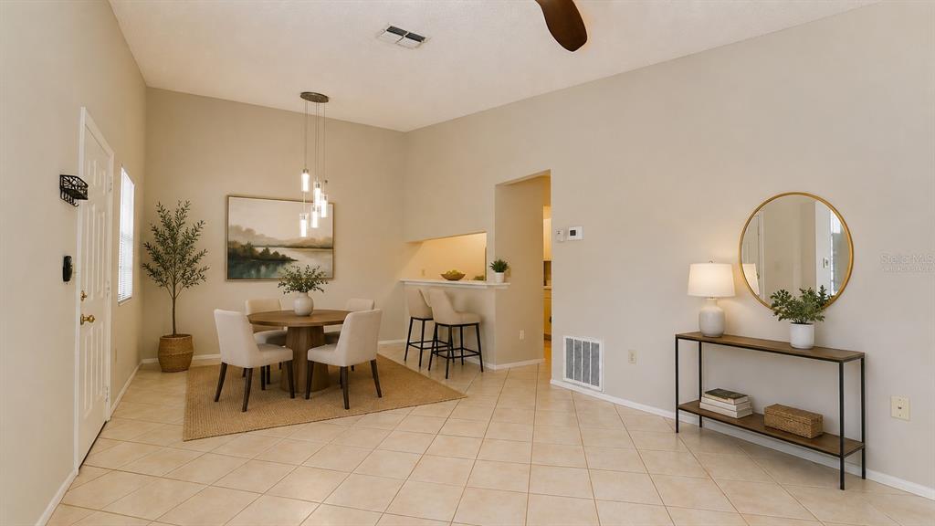 A dining area with a round table, chairs, and a console table on tiled floors — 3848 59TH AVENUE W, BRADENTON, FL