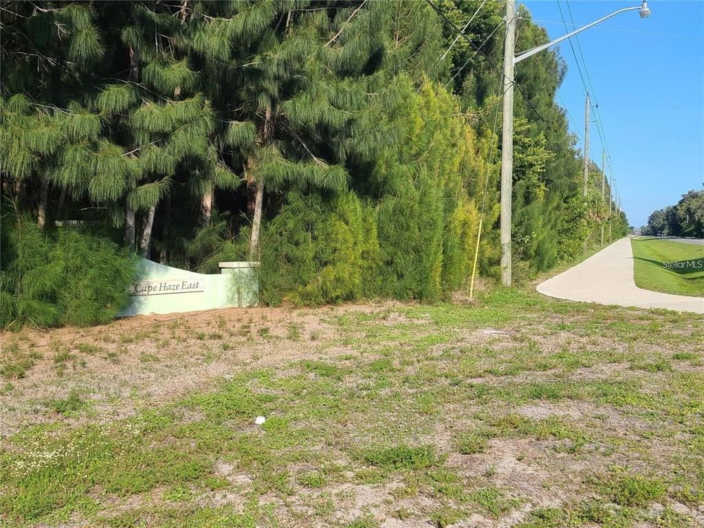 A sign for Cape Haze East stands in front of a wooded area near a sidewalk — 70 COBIA DRIVE, PLACIDA, FL