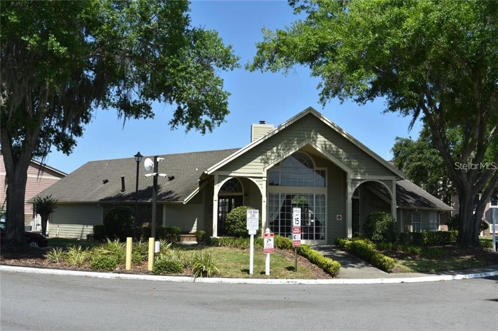 A single-story building with a gabled roof and arched entryways sits behind a paved road — 2550 N ALAFAYA TRAIL UNIT 5203, ORLANDO, FL