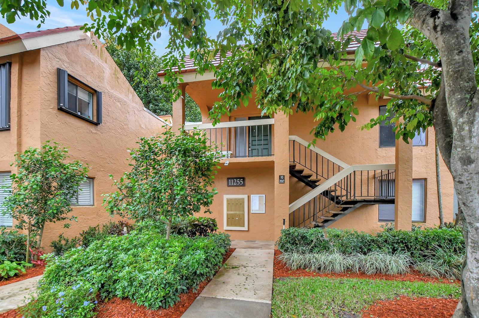 A two-story stucco apartment building with an exterior staircase and a ground-level mailbox unit — 11255 Green Lake Drive # 202, Boynton Beach FL 33437, BOYNTON BEACH, FL