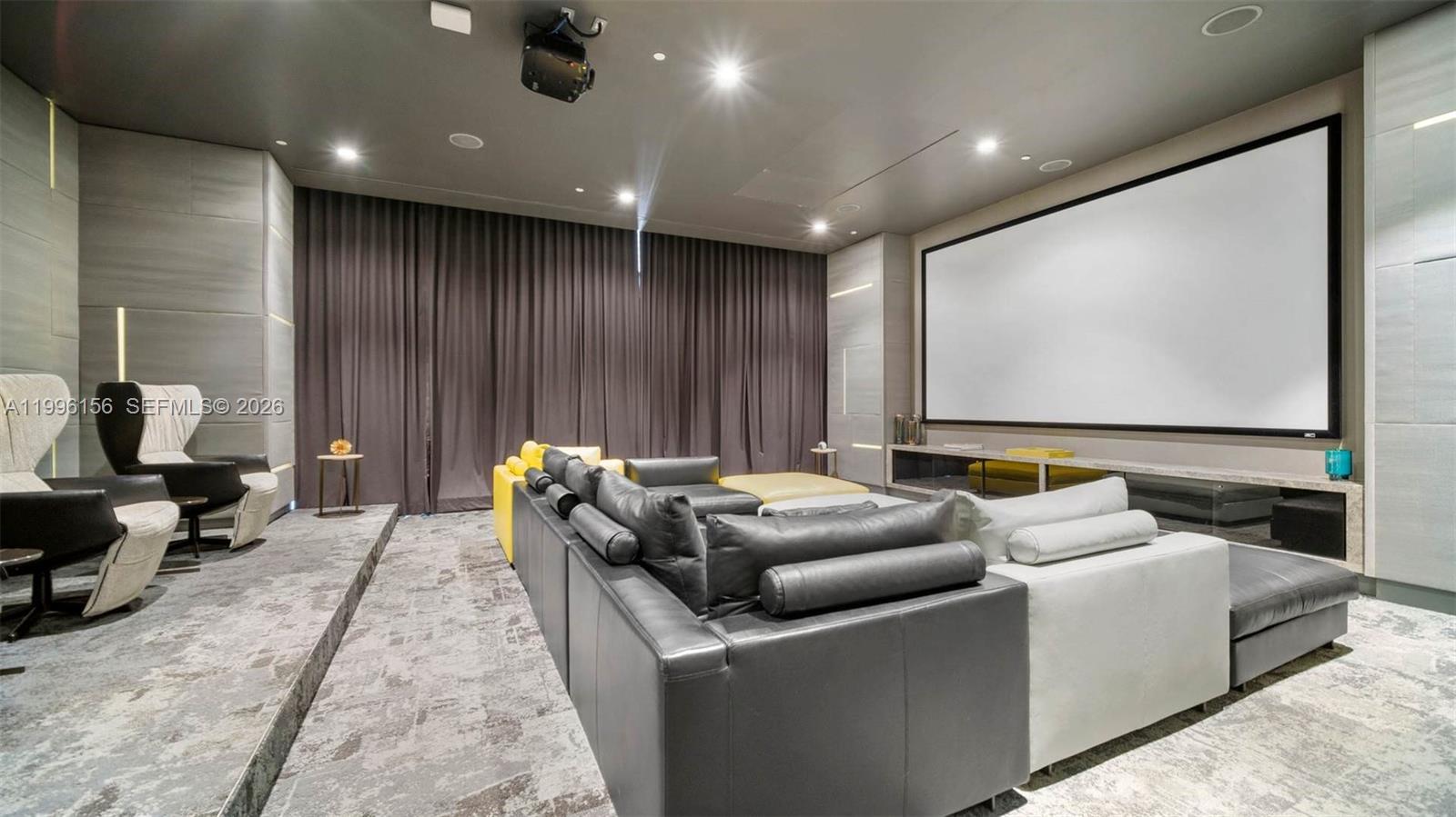 A modern home theater features a large projection screen, tiered seating, and dark curtains — 55 SW 9th # 2804, Miami FL 33130, MIAMI, FL