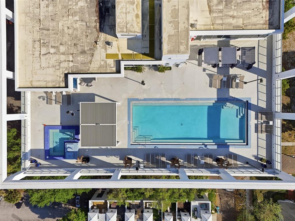 An aerial view of a rooftop pool deck featuring lounge chairs, a hot tub, and cabanas — 260 S OSCEOLA AVENUE UNIT 902, ORLANDO, FL