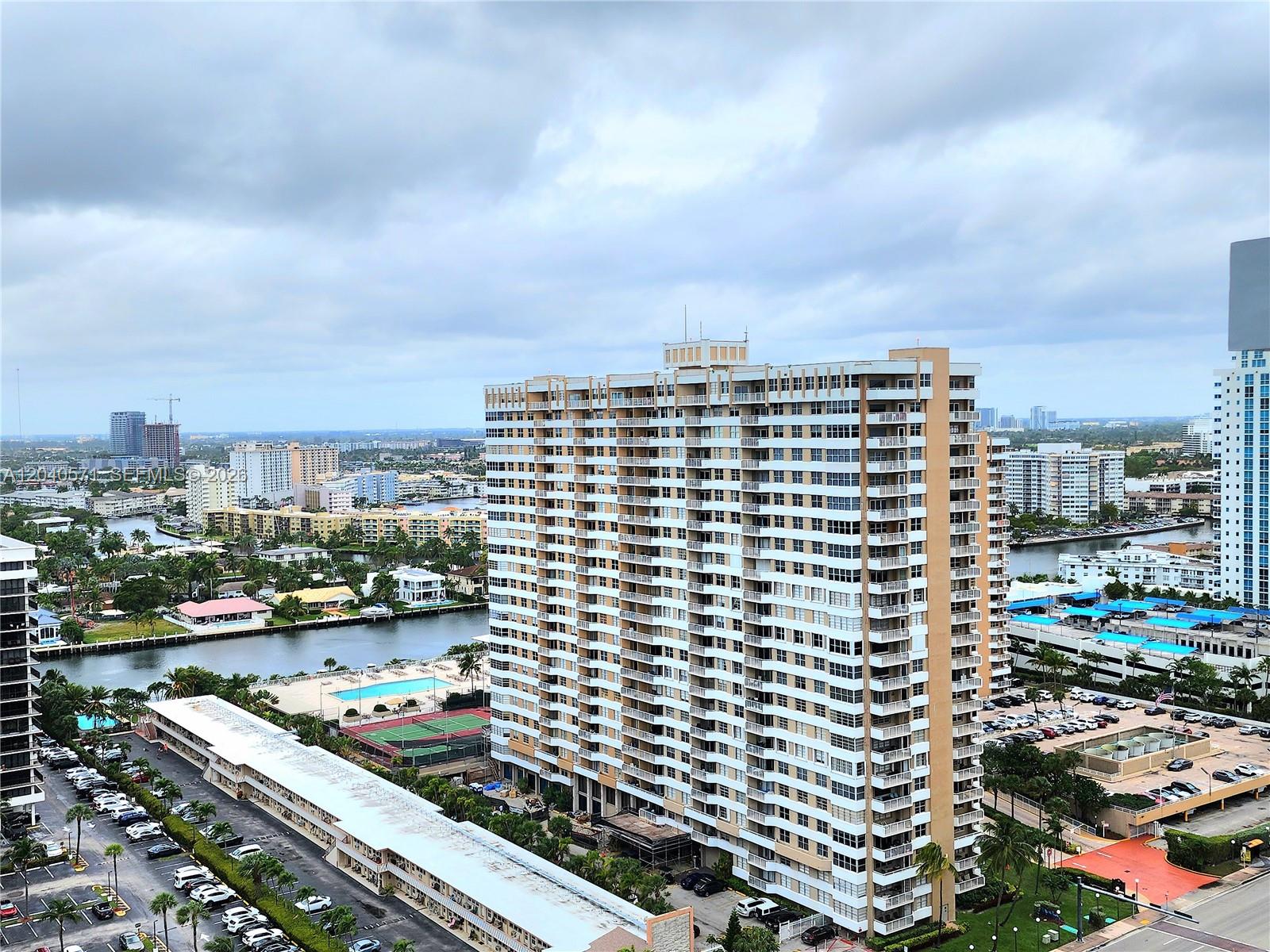 An aerial view shows a tall residential apartment building next to a canal and parking — 2030 S Ocean Dr # 2204, Hallandale Beach FL 33009, HALLANDALE BEACH, FL