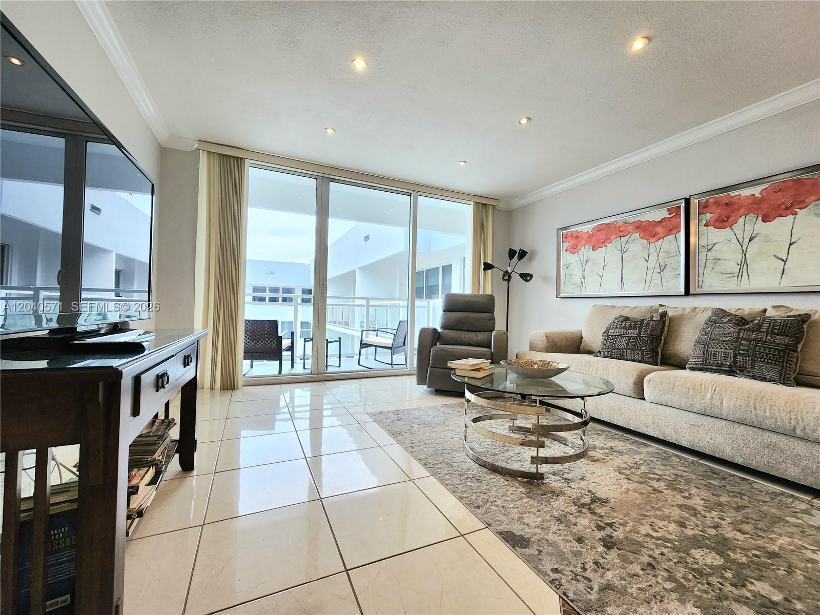A living room features tile floors, a glass coffee table, a sofa, and balcony access — 2030 S Ocean Dr # 2204, Hallandale Beach FL 33009, HALLANDALE BEACH, FL