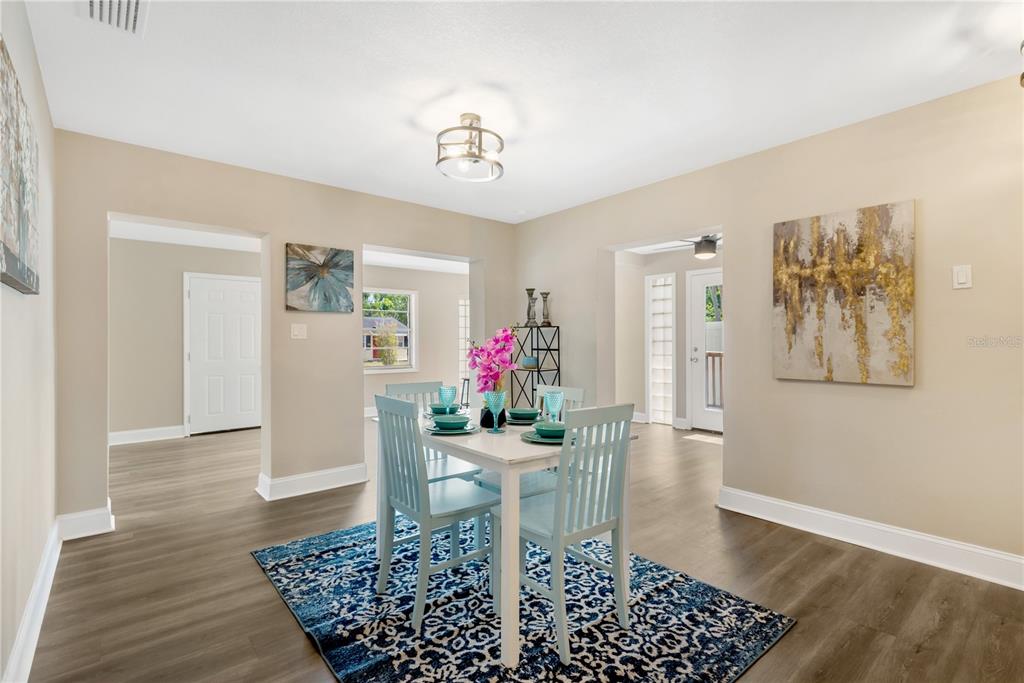 A dining room with a white table, light blue chairs, and a blue patterned rug — 3903 W PALMETTO STREET, TAMPA, FL