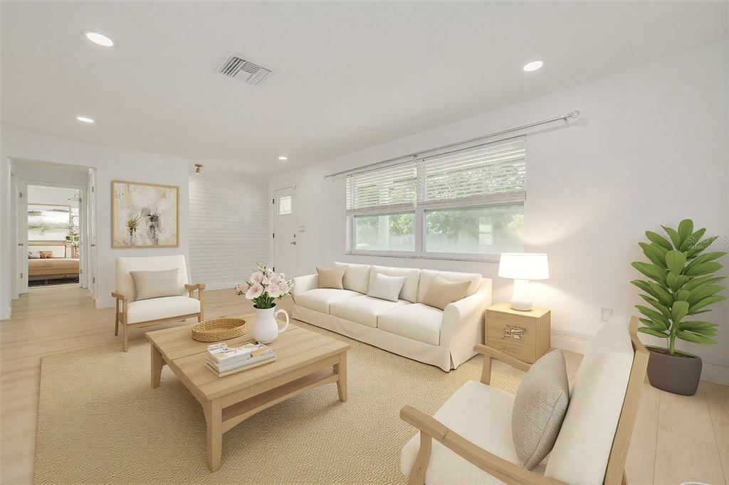 This is a digitally staged living room with white walls, light wood flooring, and a sofa — 2631 OAKBROOK DRIVE, LARGO, FL