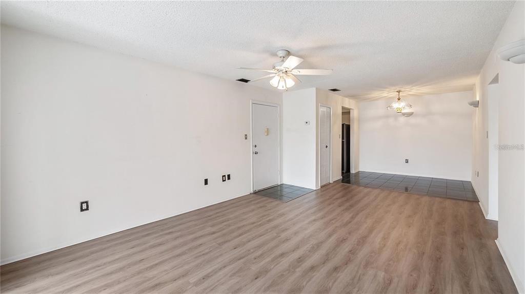 An open-concept living area features wood-look flooring, a ceiling fan, and a tiled entryway — 314 CHEROKEE COURT UNIT H, ALTAMONTE SPRINGS, FL