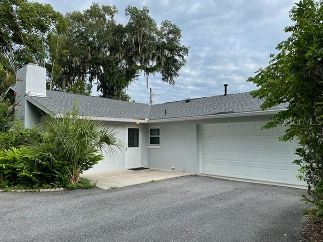 A single-story house with a gray exterior, a white garage door, and a paved driveway — 2190 SE 39TH STREET, OCALA, FL