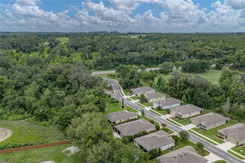 An aerial view shows a suburban neighborhood with several single-story houses and surrounding wooded areas — 12322 EASTPOINTE DRIVE, DADE CITY, FL