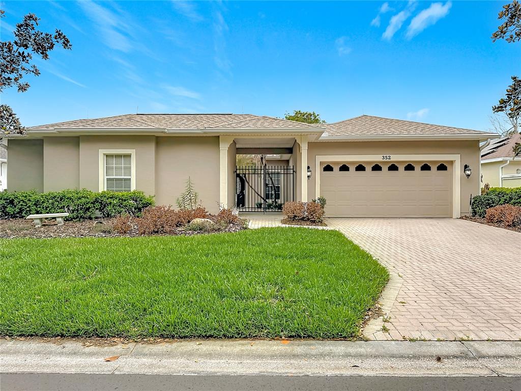 An aerial view shows a tan house with a light-colored roof and a courtyard — 352 HAMRICK DRIVE, KISSIMMEE, FL