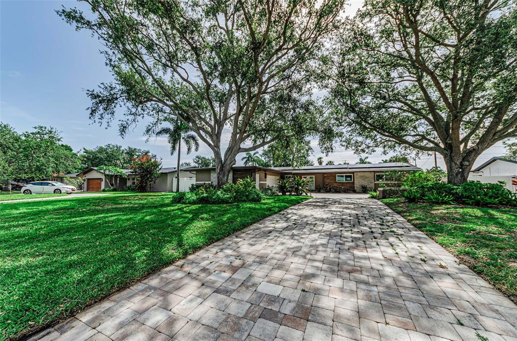 A single-story house with a paved driveway and large trees in the front yard — 861 RAFAEL BOULEVARD NE, ST PETERSBURG, FL