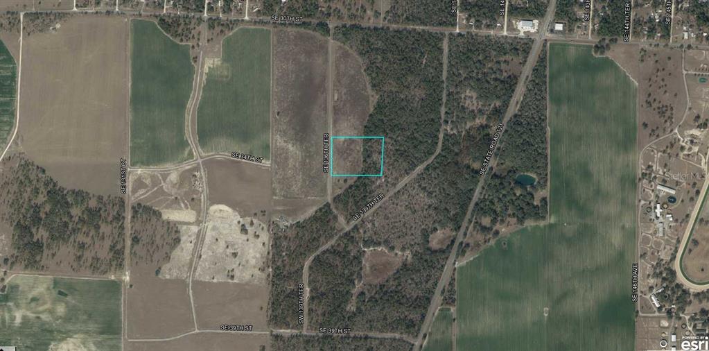 An aerial view shows a rectangular plot of land outlined in white beside a road — SE 136TH TERRACE, MORRISTON, FL