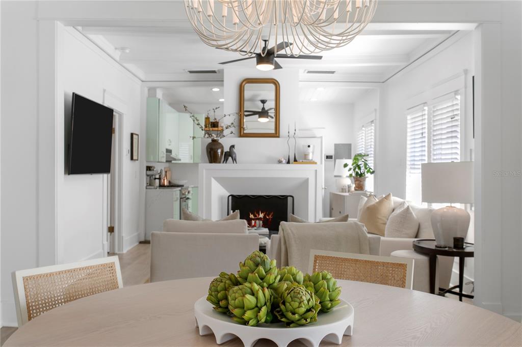 A dining area with a bowl of artichokes overlooks a living room with a fireplace — 3407 W SAN PEDRO STREET, TAMPA, FL