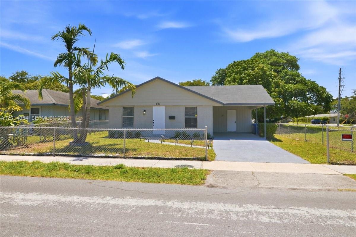 A single-story house with a light gray exterior, a front carport, and a chain-link fence — 921 NW 5th Ave, Pompano Beach FL 33060, POMPANO BEACH, FL