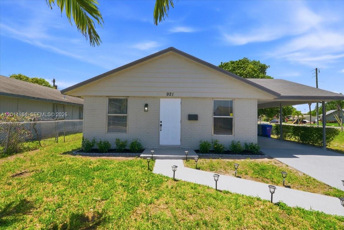A single-story house with a light-colored brick facade and an attached carport — 921 NW 5th Ave, Pompano Beach FL 33060, POMPANO BEACH, FL