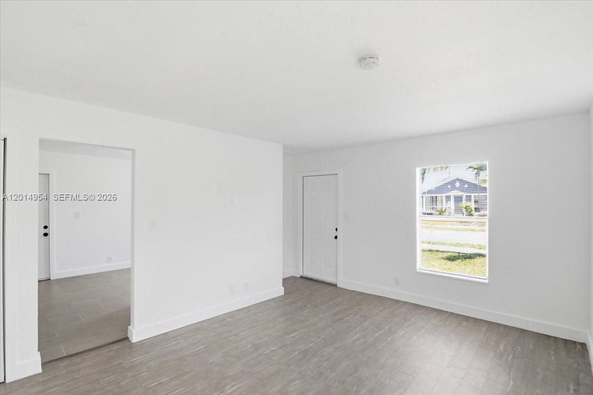 An interior view of a room with white walls, gray flooring, and a white door — 921 NW 5th Ave, Pompano Beach FL 33060, POMPANO BEACH, FL