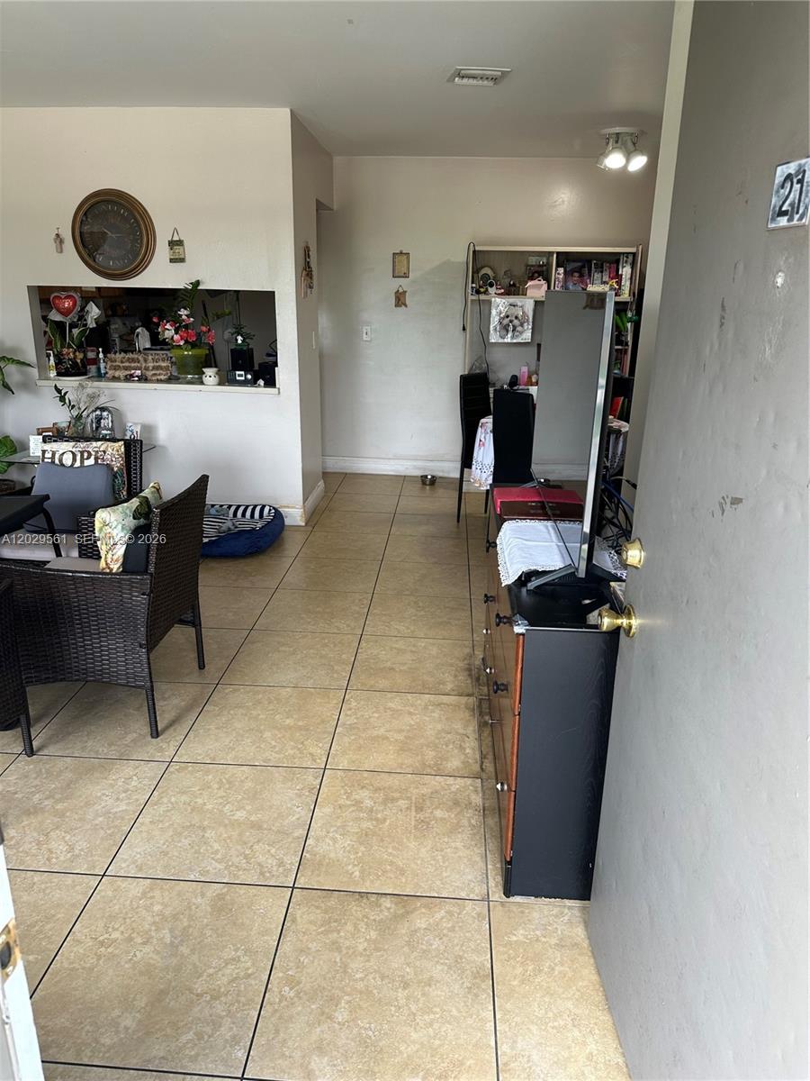 An interior view shows a tiled entryway leading into a living area with a pass-through window — 15360 SW 72 ST # 21, Miami FL 33193, MIAMI, FL