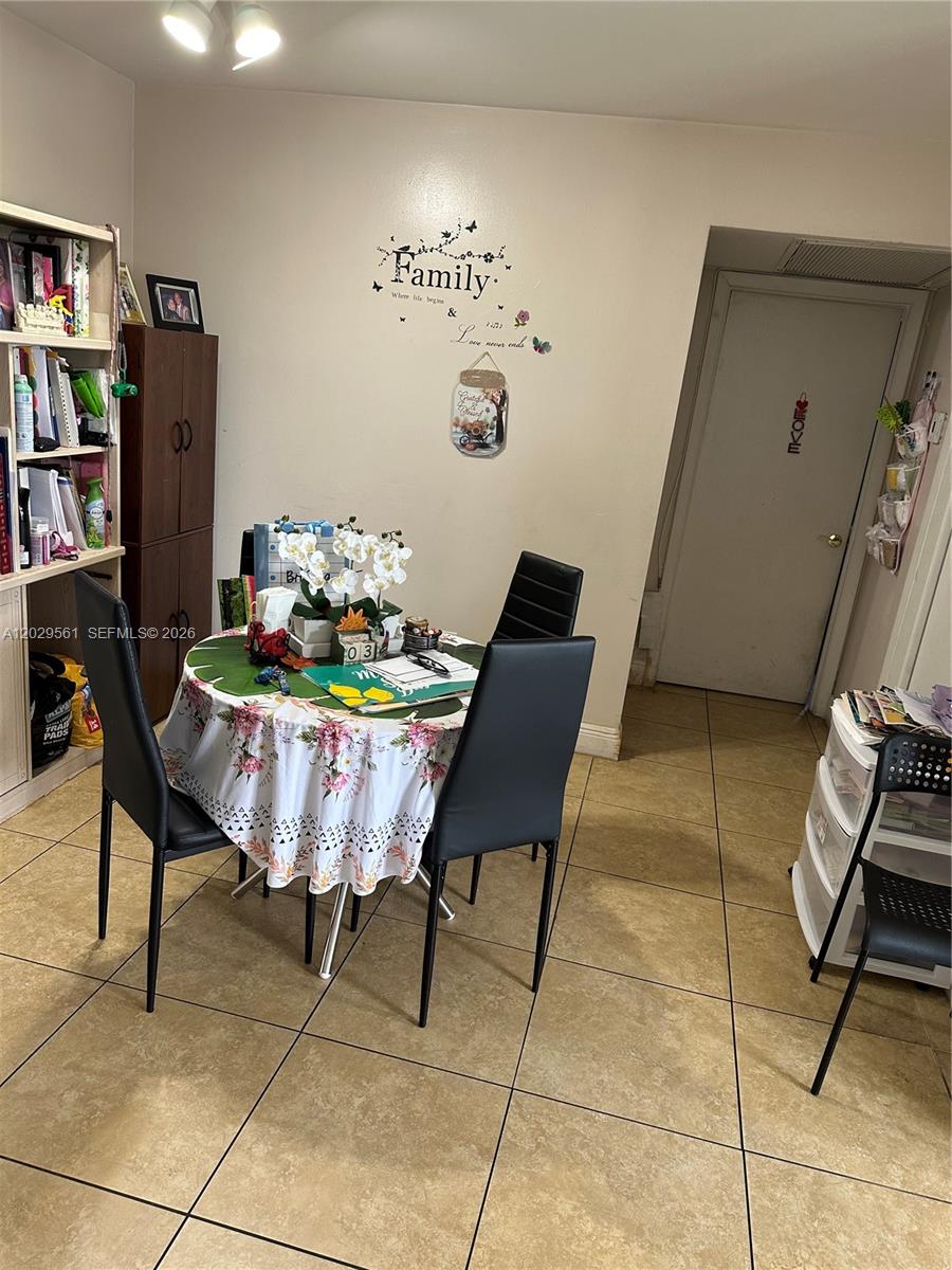 A dining area features a round table with four black chairs on tiled flooring — 15360 SW 72 ST # 21, Miami FL 33193, MIAMI, FL