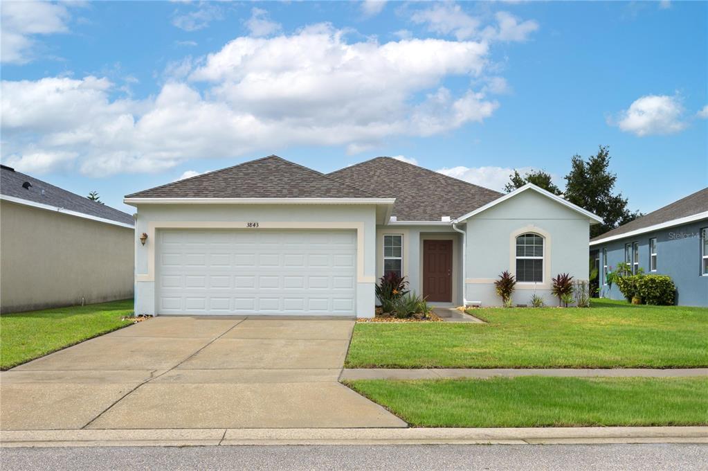 A single-story house with a two-car garage, light blue siding, and a brown shingled roof — 3843 ELOISE ESTATES COURT, WINTER HAVEN, FL