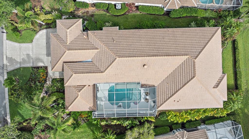 An aerial view shows a house with a tiled roof and a screened-in pool enclosure — 7507 ASCOT COURT, BRADENTON, FL