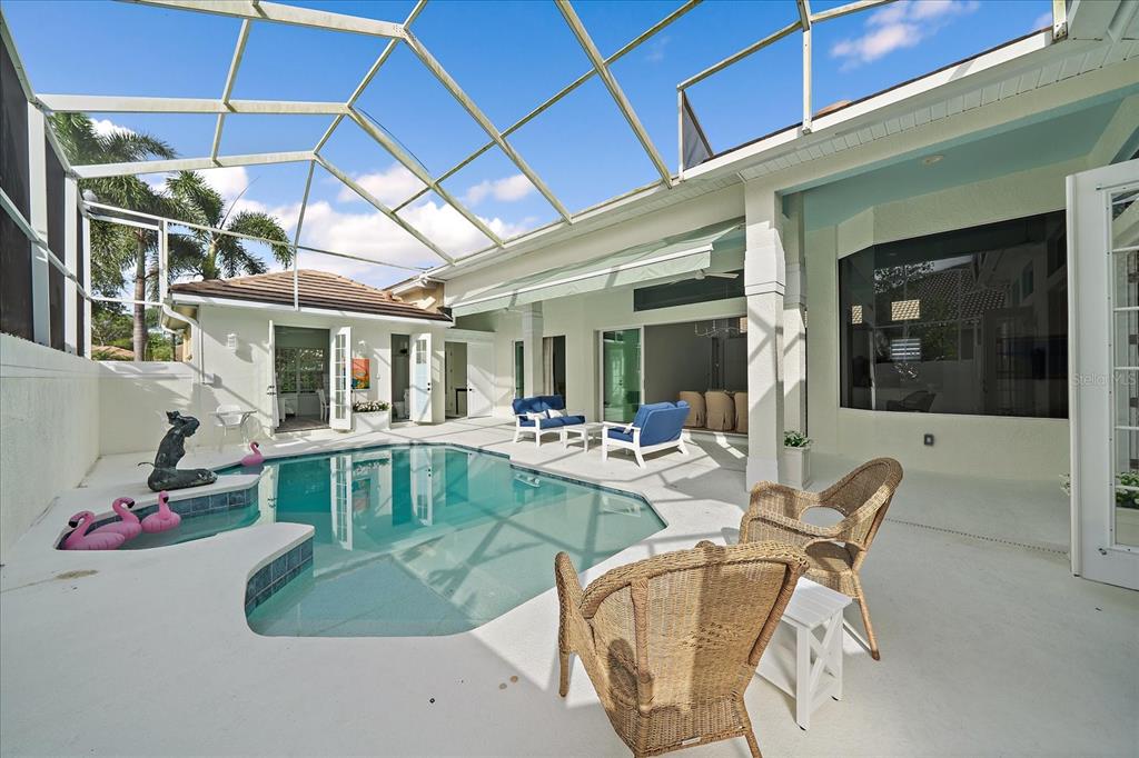 A screened-in patio features a swimming pool, a spa, and outdoor seating furniture — 7507 ASCOT COURT, BRADENTON, FL