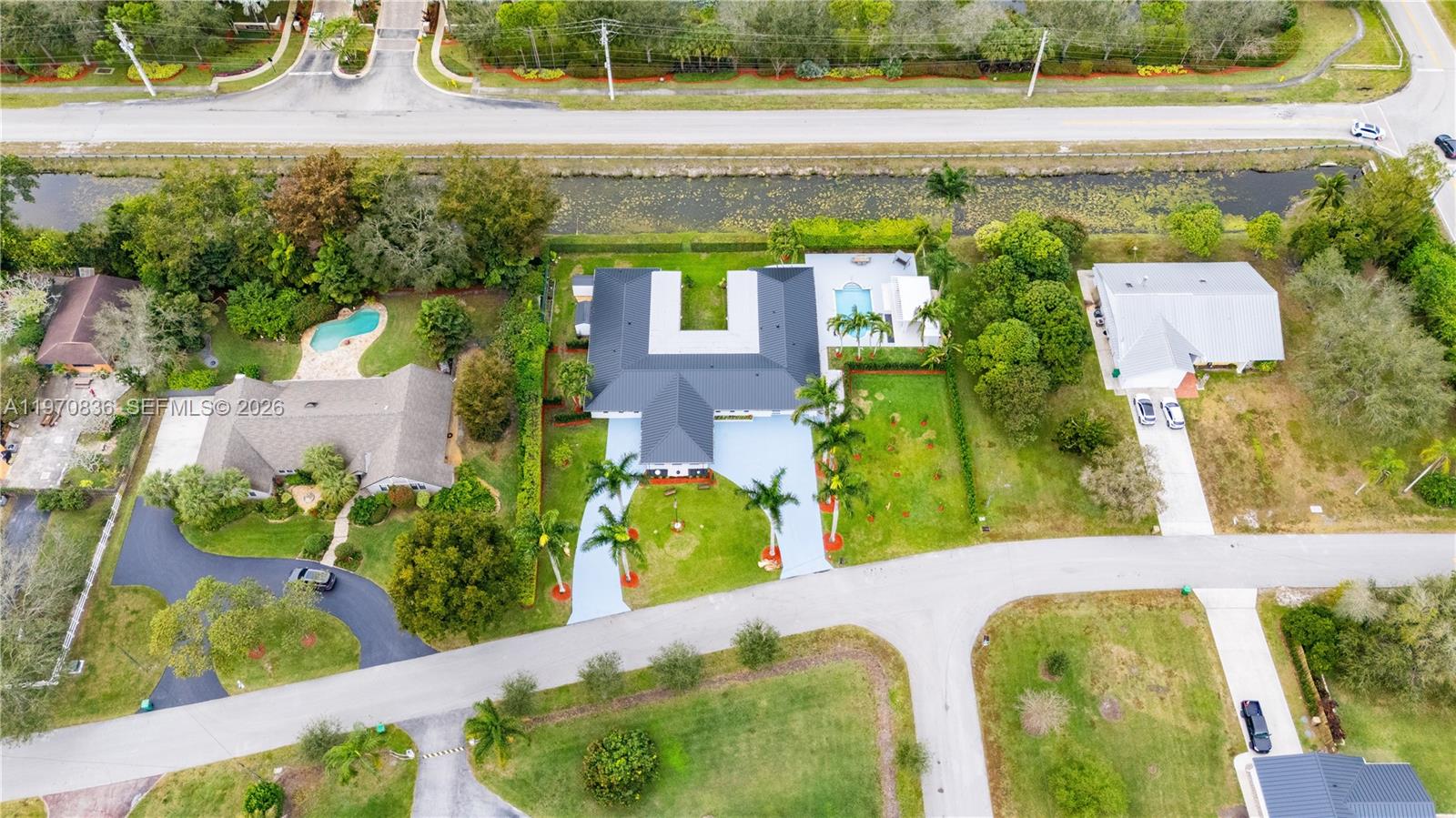 An aerial view shows a house with a dark roof, pool, and surrounding landscaping — 2651 SW 141st Ter, Davie FL 33330, DAVIE, FL