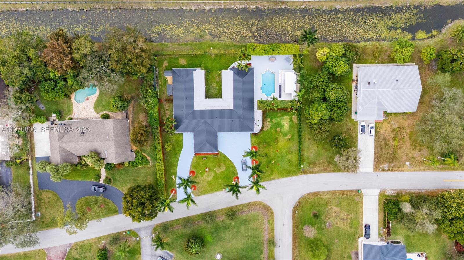 An aerial view shows a U-shaped house with a pool, driveway, and surrounding green landscaping — 2651 SW 141st Ter, Davie FL 33330, DAVIE, FL