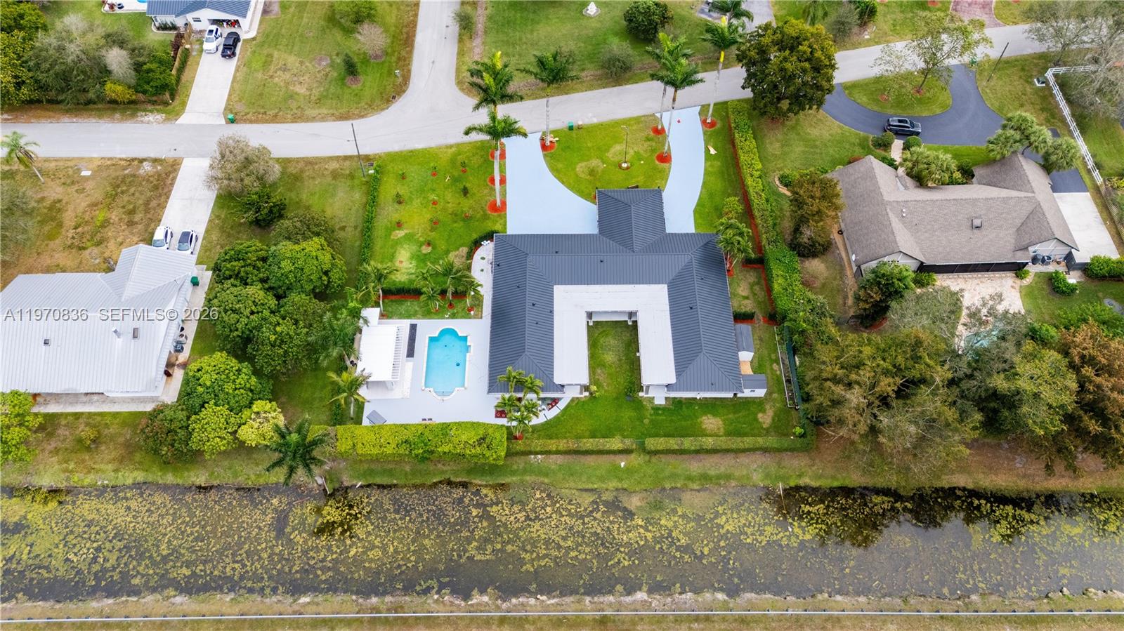 An aerial view shows a house with a dark roof, pool, and circular driveway — 2651 SW 141st Ter, Davie FL 33330, DAVIE, FL