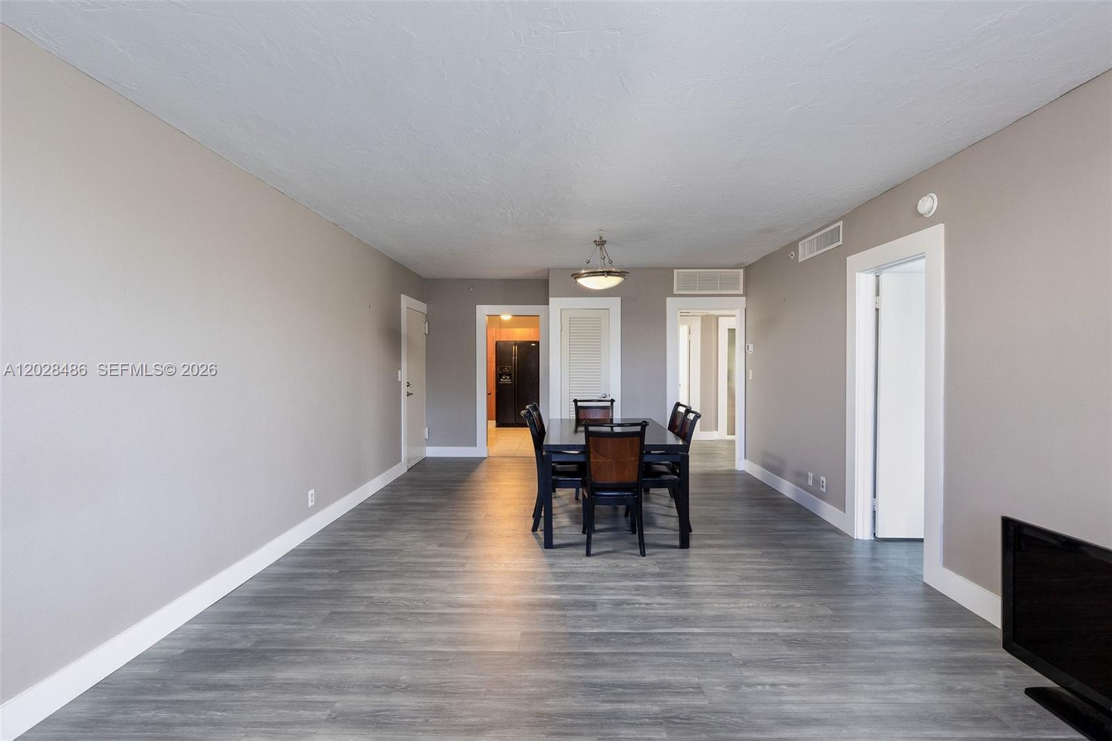 A dining area features a dark wood table and chairs on grey wood-look flooring — 3001 S Ocean Dr # 227, Hollywood FL 33019, HOLLYWOOD, FL
