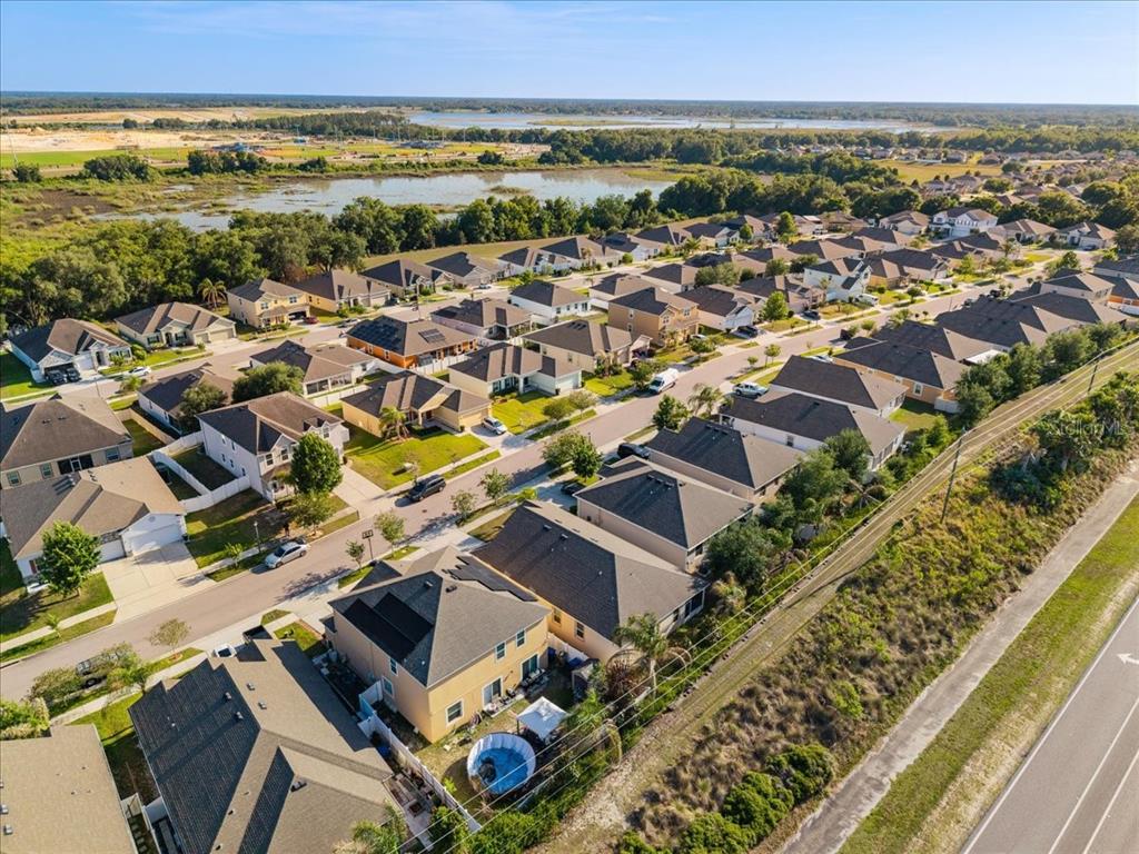 An elevated view of a single-story beige house with a two-car garage and landscaping — 1269 WATER WILLOW DRIVE, GROVELAND, FL