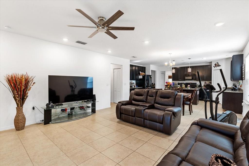A covered front porch features a swing, potted plants, and a brown front door — 1269 WATER WILLOW DRIVE, GROVELAND, FL