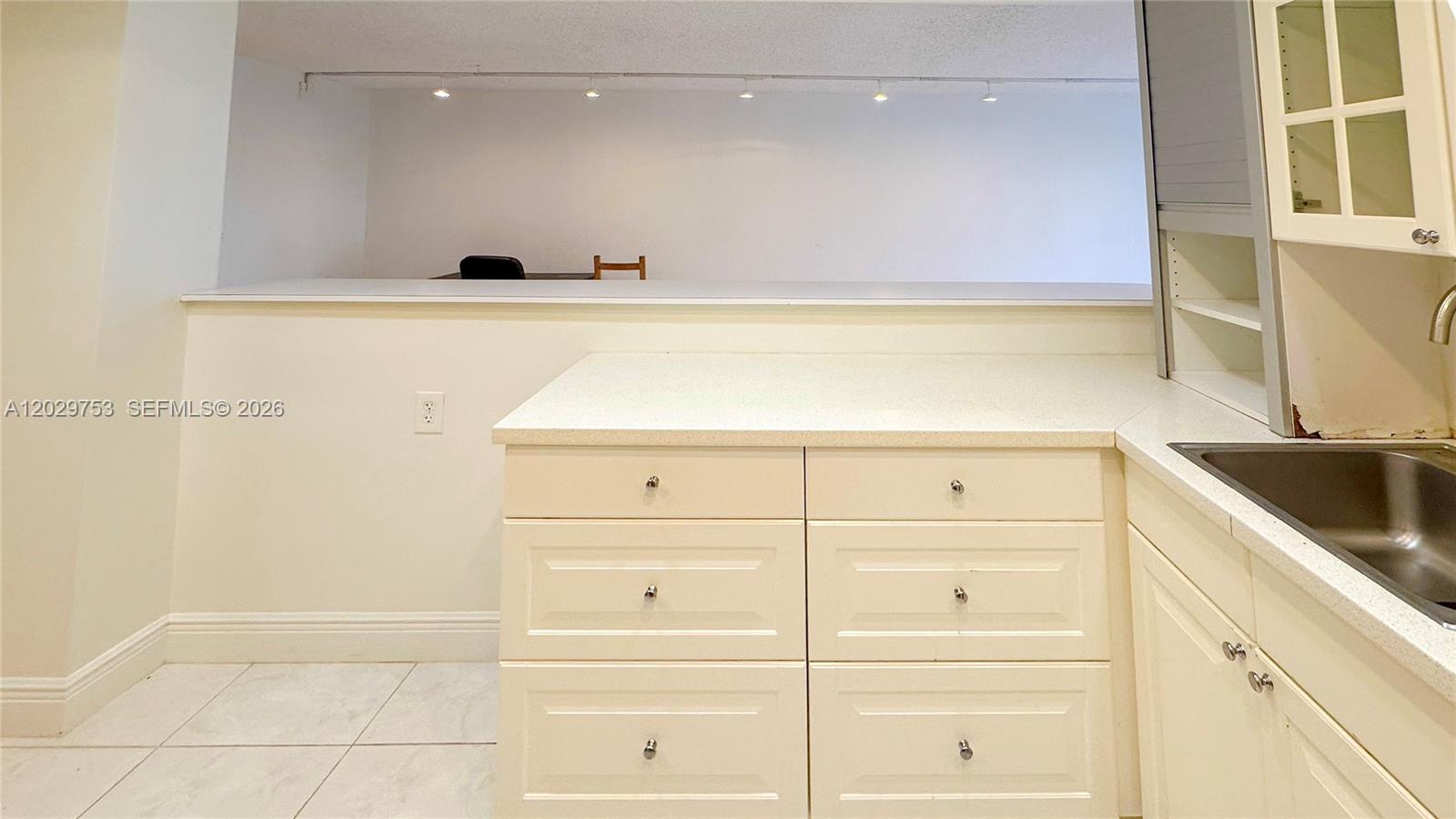 A kitchen features white cabinetry, a countertop, a stainless steel sink, and recessed lighting — 800 Parkview Dr # 323, Hallandale Beach FL 33009, HALLANDALE BEACH, FL
