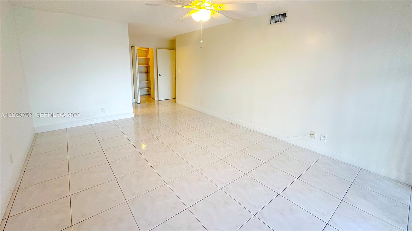An empty room features white walls, light-colored tile flooring, and a ceiling fan — 800 Parkview Dr # 323, Hallandale Beach FL 33009, HALLANDALE BEACH, FL