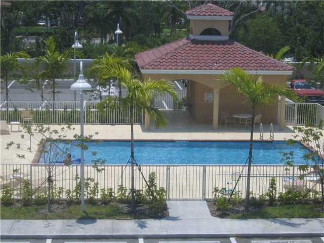 An outdoor swimming pool with a covered pavilion and palm trees in a fenced area — 519 E Sheridan Street # 3072, Dania Beach FL 33004, DANIA BEACH, FL