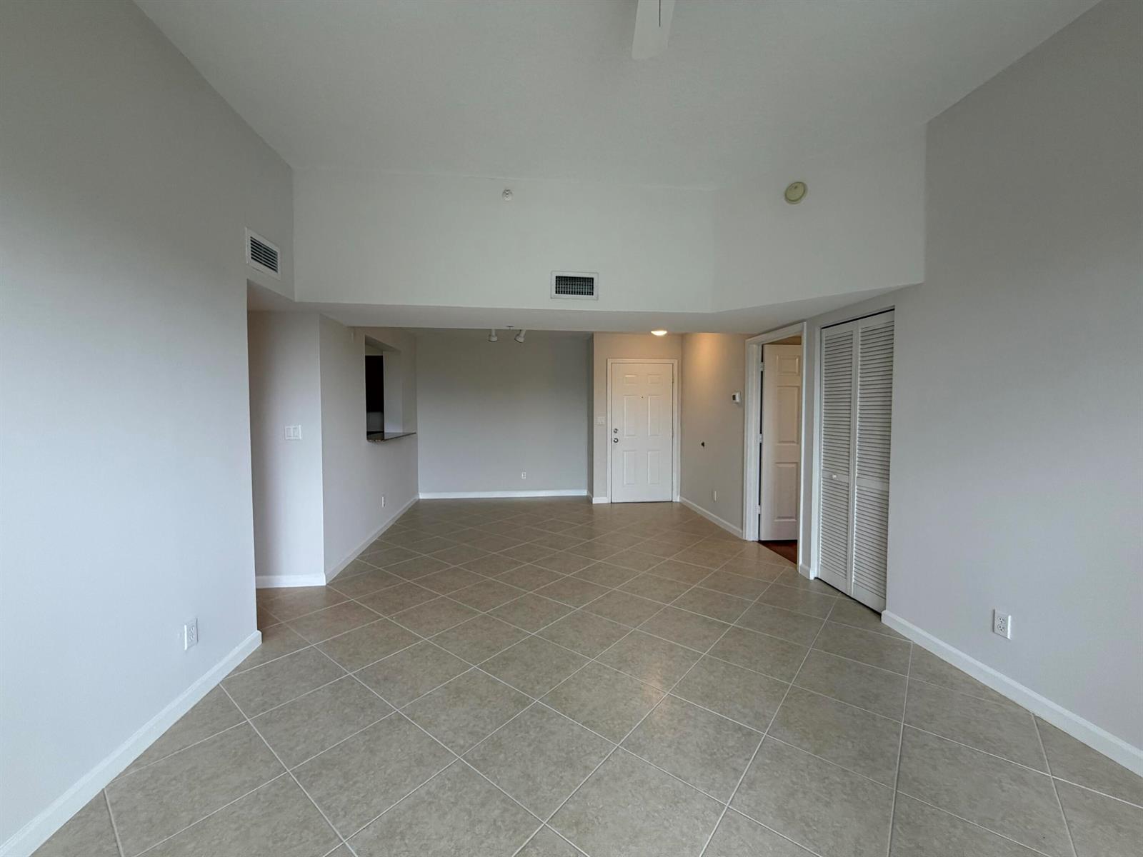 An empty room with light-colored walls, tiled floors, a white door, and a closet — 519 E Sheridan Street # 3072, Dania Beach FL 33004, DANIA BEACH, FL