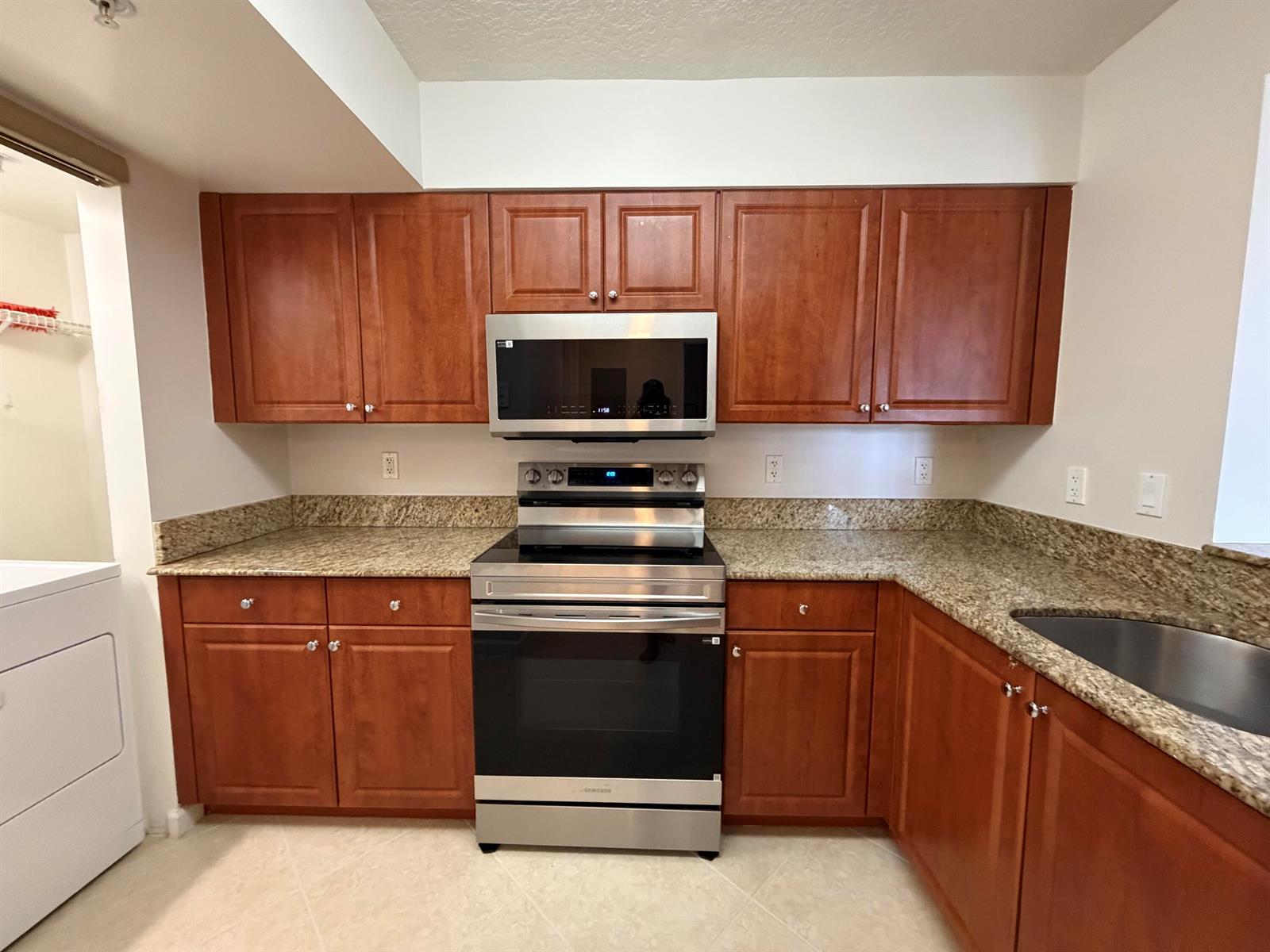 A kitchen features cherry wood cabinets, granite countertops, and stainless steel appliances — 519 E Sheridan Street # 3072, Dania Beach FL 33004, DANIA BEACH, FL