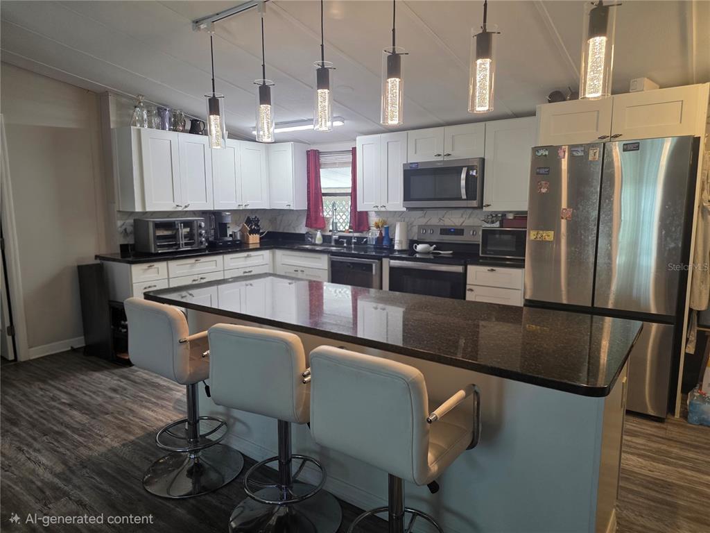 A kitchen with white cabinets, a dark granite island, and three bar stools — 1855 BRAMBLEWOOD DRIVE, ST CLOUD, FL
