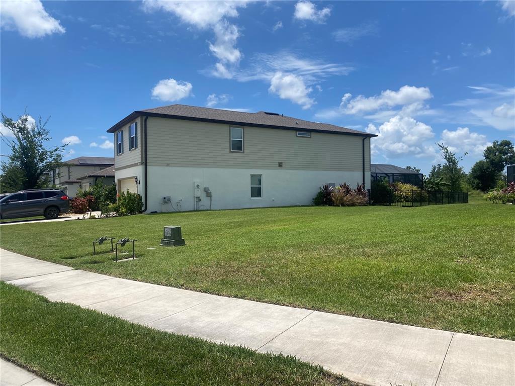 A two-story house with beige siding and a white stucco base sits on a lawn — 9126 ROYAL RIVER CIRCLE, PARRISH, FL