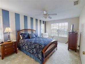 A bedroom features a bed with a blue patterned comforter against a blue-striped accent wall — 4544 NW 30TH PLACE, OCALA, FL