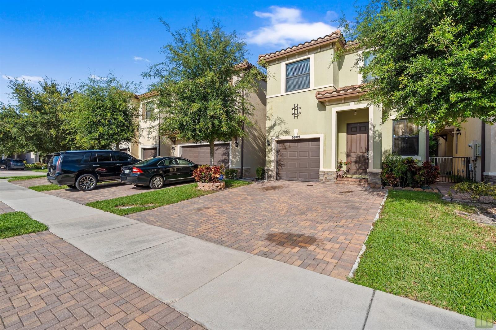 A two-story house with a paver driveway, a one-car garage, and a brown front door — 5809 NW 46th Lane, Tamarac FL 33319, TAMARAC, FL