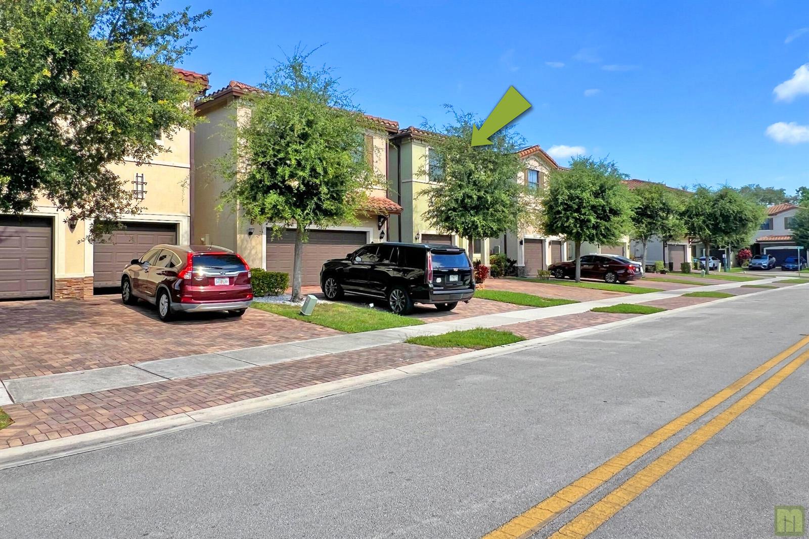 A row of two-story townhomes with garages and paved driveways under a clear blue sky — 5809 NW 46th Lane, Tamarac FL 33319, TAMARAC, FL