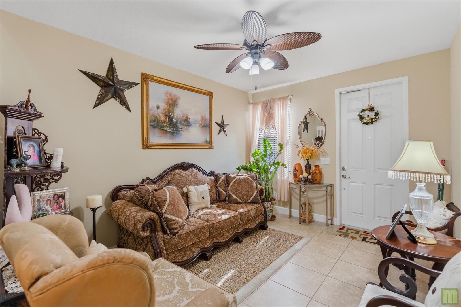 A living room features a patterned sofa, a ceiling fan, and a front entry door — 5809 NW 46th Lane, Tamarac FL 33319, TAMARAC, FL