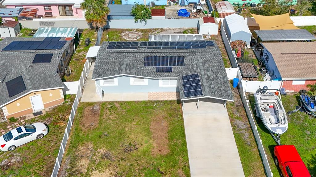 An aerial view shows a single-story house with solar panels on the roof and a driveway — 4606 BYERLE CIRCLE, TAMPA, FL