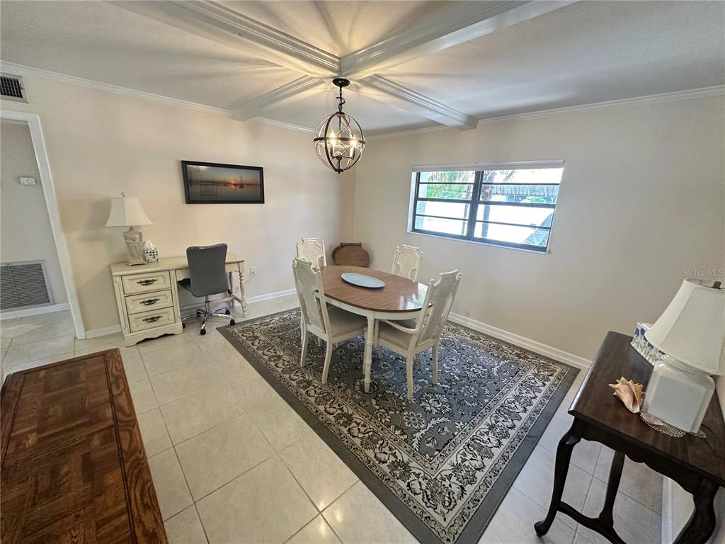 A dining room features a wooden table, four chairs, a desk, and a patterned area rug — 4572 RED MAPLE ROAD UNIT 901, BRADENTON, FL